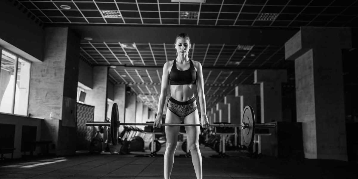 female-athlete-training-with-barbell-in-sport-gym-PJK9SVA